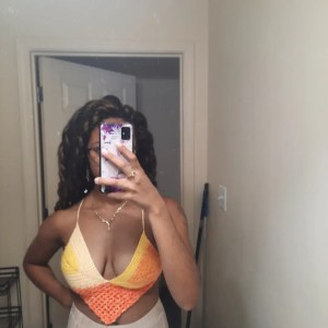 Me wearing a red, orange, and yellow crochet top