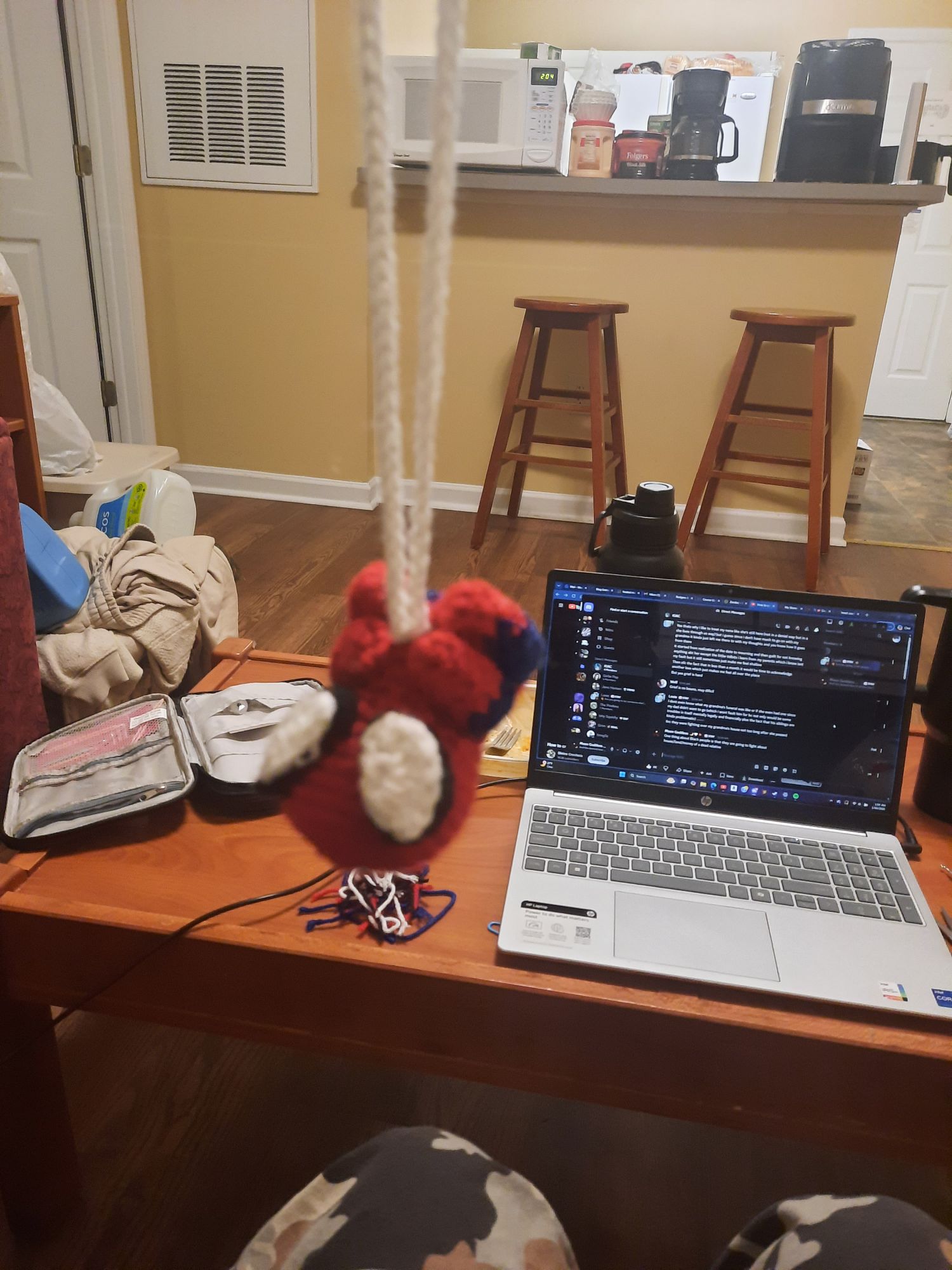 Picture of a small crochet Spiderman hanging upside down on a crochet web