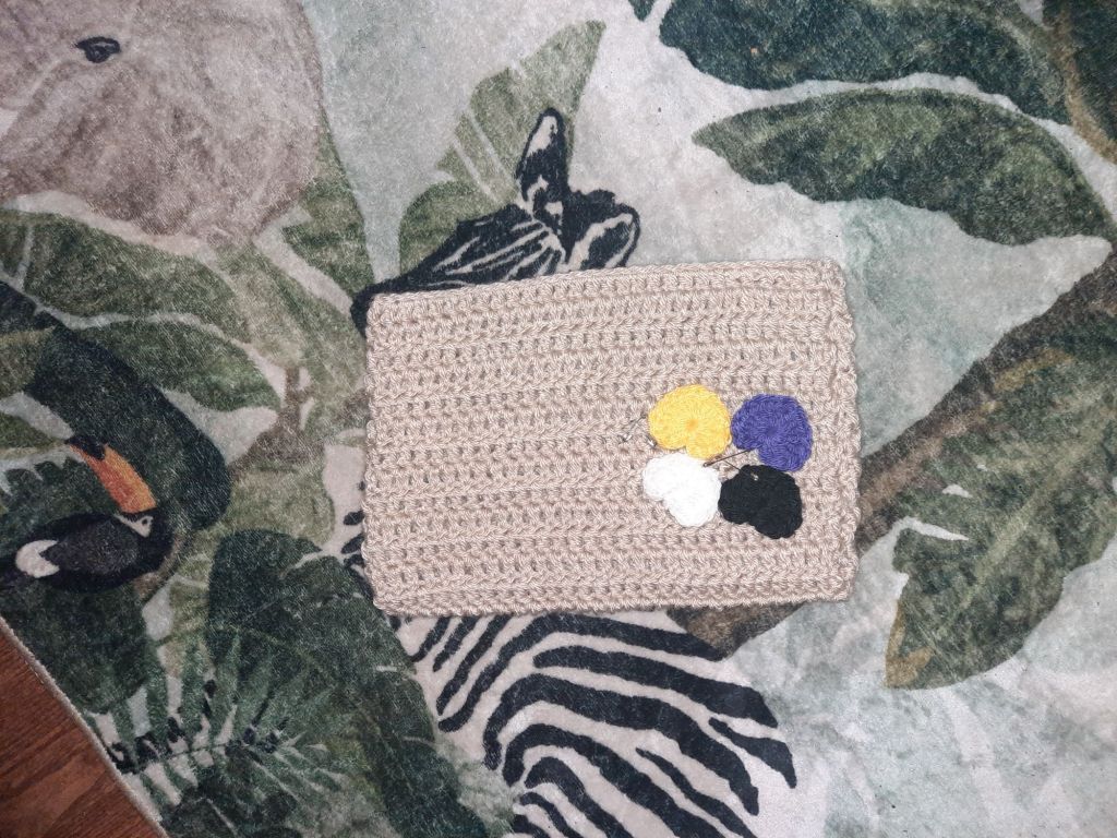 Beige cat hat with nonbinary flag colored hearts on top