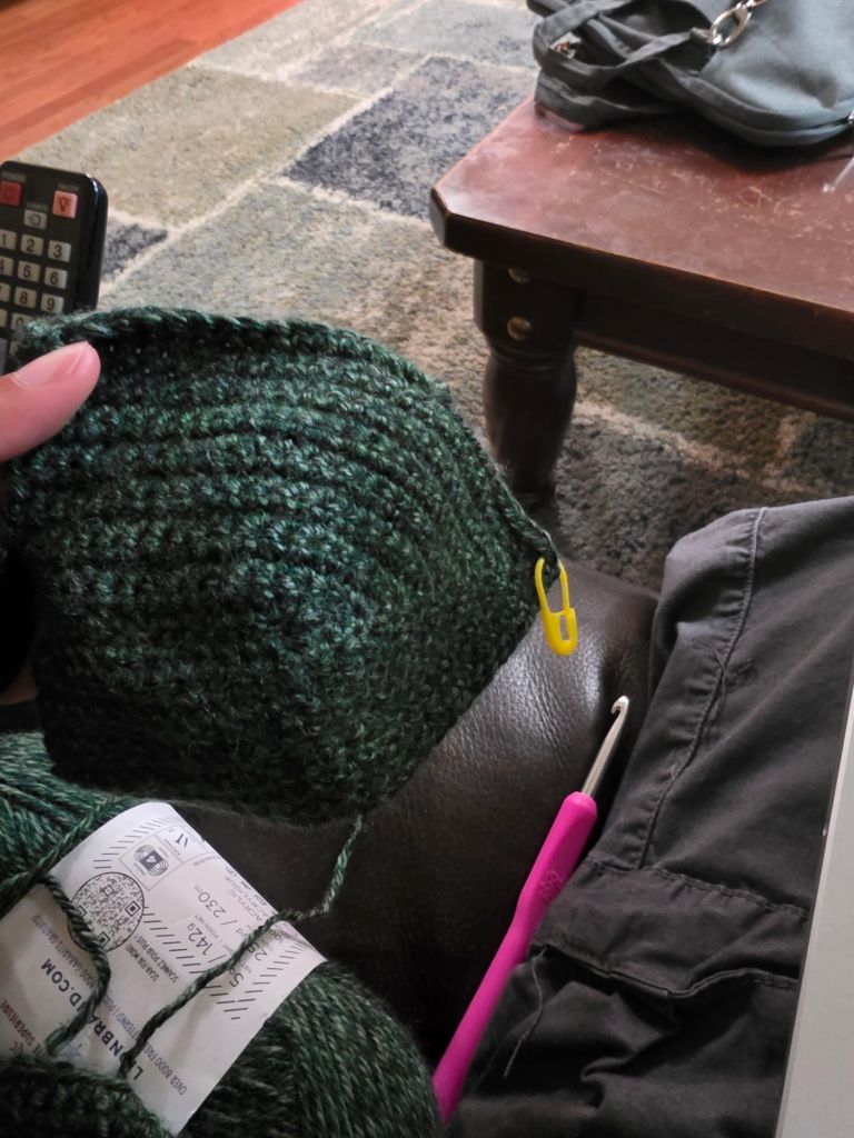Me holding a dark green crochet shirt cup